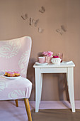 Stool, armchair and romantic accessories against brown wall