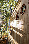 Holzverfassade eines Tiny Houses mit runden Bullaugenfenstern