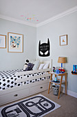 Batman motif above child's bed with black-and-white, star-patterned bed linen