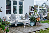 Terrace with a Christmas tree, lanterns and a bench with a blanket, fur and pillows