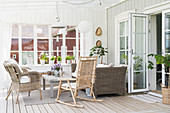 Wicker furniture and rocking chair in country-house-style conservatory