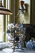 Various vintage-style cups hung on old bottle rack