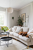 Pale sofa and black coffee table in living room with pale grey walls