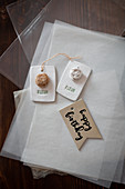 Gift tags with flower motifs and birthday greeting lying on tissue paper