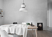 Heller Holztisch mit weißer Tischdecke, Karaffe und Eukalyptuszweig