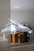Doppelbett mit Betttruhe in schlichtem beigefarbenem Raum