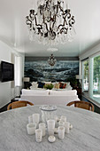 Dining table with marble top in front of lounge with maritime mural wallpaper