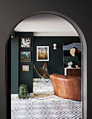 View through arch into living room with dark green wall