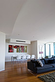 Sofa und Esstisch in modernem Wohnraum mit hoher kuppelförmiger Decke