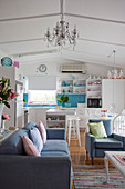 Wohnraum in Weiß-Blau mit offener Küche und Sitzbereich mit Couch und Sesseln