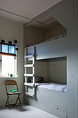 Grey cubby bunk beds with ladder in vintage-style children's bedroom