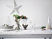 Weihnachtsdekoration, Geschirr, Gläser und Besteck auf weissem Holztisch