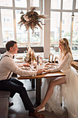 Bride and groom sitting at set table