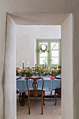 Festively set Christmas table seen through open dining room doorway