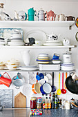 Crockery and spices on kitchen shelves and worktop