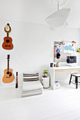 Guitars on wall, floor cushions and desk in teenager's bedroom