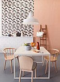 Dining area in front of ledge, patterned wallpaper and apricot wall