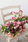 Handmade flower arrangement of Peruvian lilies, calla lilies and red onions in wine box