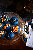 Perfectly decorated cupcakes with dark blue and gold toppings