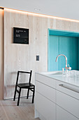 Pale wood and blue seating niche in modern, minimalist kitchen
