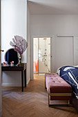 Elegante Polsterbank vorm Bett im Schlafzimmer mit Bad
