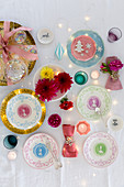 Christmas arrangement of decorative china plates, flowers and tealights