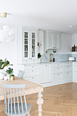 Kitchen-dining room in Scandinavian country-house style with pale grey cabinets