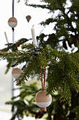 Kerze und Holzkugel am Weihnachtsbaum