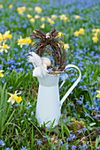 Small Easter nest with egg-shaped wreath on top of tin jug