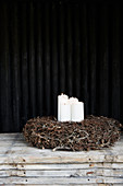 Four white candles in rustic wreath