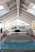 Double bed in attic room with wooden ceiling