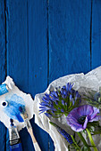 Anemone, Schmucklilie, Ehrenpreis und Edeldistel auf blauen Brettern