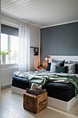 Double bed against grey wall in bedroom
