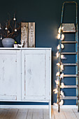 White cabinet and vintage metal ladder with fairy lights