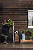 Frau hängt Weihnachtsdeko an Holzwand