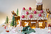 Decorated gingerbread house with deer figurines and lights