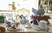 Table set for Easter breakfast with hen ornament in nest