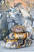 Stacked pebbles painted with marble pour technique in natural colours