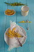 Mimosa flowers decorating kitchen plate, cutlery rest and porcelain dish
