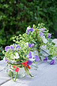 Bouquets of sweet peas and lady's mantle in mason jars