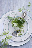 Cutlery arranged with sweet peas and lady's mantle on plate