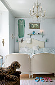 Chandelier above antique bed in vintage-style bedroom