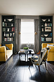Two yellow sofas facing one another in symmetrical living room in shades of grey