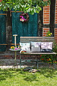 Cushions on bench outside house with petrol-blue wooden doors