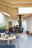 Modernes Wohnzimmer in skandinavischem Design, hängender Kamin und Holzdecke