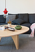 Modernes Wohnzimmer in skandinavischem Design, Pendelleuchte über Couchtisch aus Holz