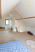 Dachgeschoss mit sichtbaren Holzbalken und minimalistischer Einrichtung