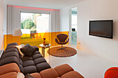 Modernes Wohnzimmer mit großer Fensterfront und Designer-Sessel