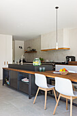 Modern kitchen unit with bar stools and integrated dining area