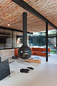 Living room with suspended fireplace, brick ceiling and orange sofa